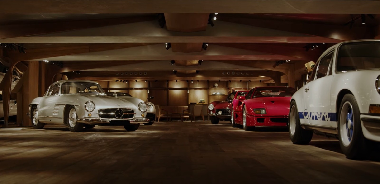 Una biblioteca-garaje de lujo rodeada de coches clásicos