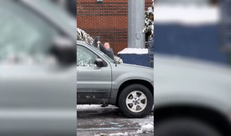 Mujer trata de quitar el hielo de su coche