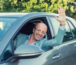conductor coche saludando