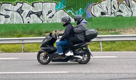 Pasajero de una moto utilizando el móvil