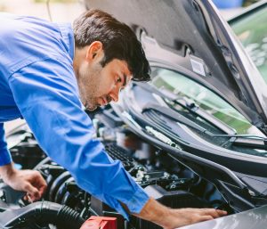 Joven mirando motor coche