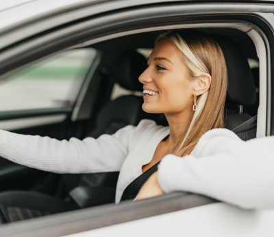 Mujer conduciendo codo ventanilla
