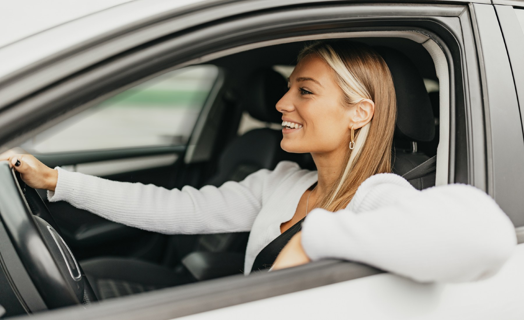 Mujer conduciendo codo ventanilla