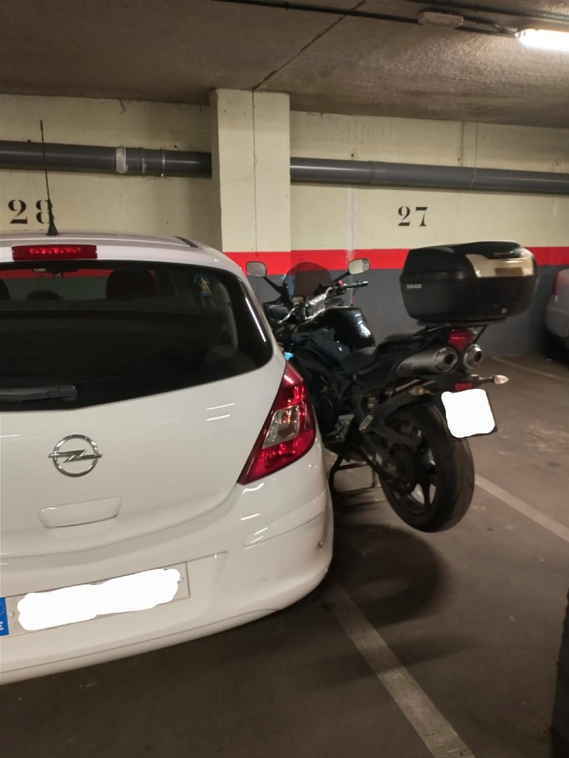 Moto mal estacionada en el garaje.