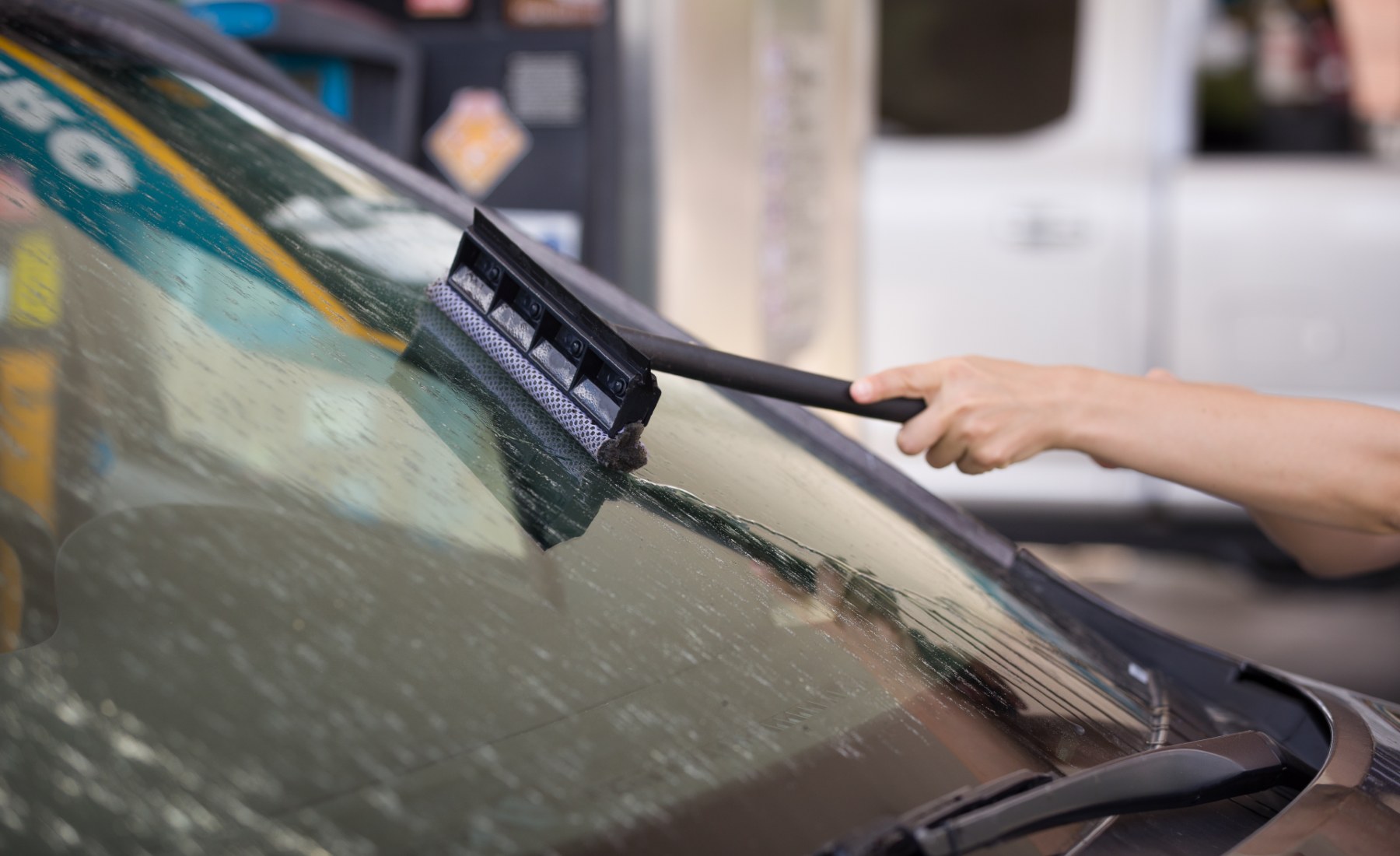 Limpiando parabrisas coche en gasolinera