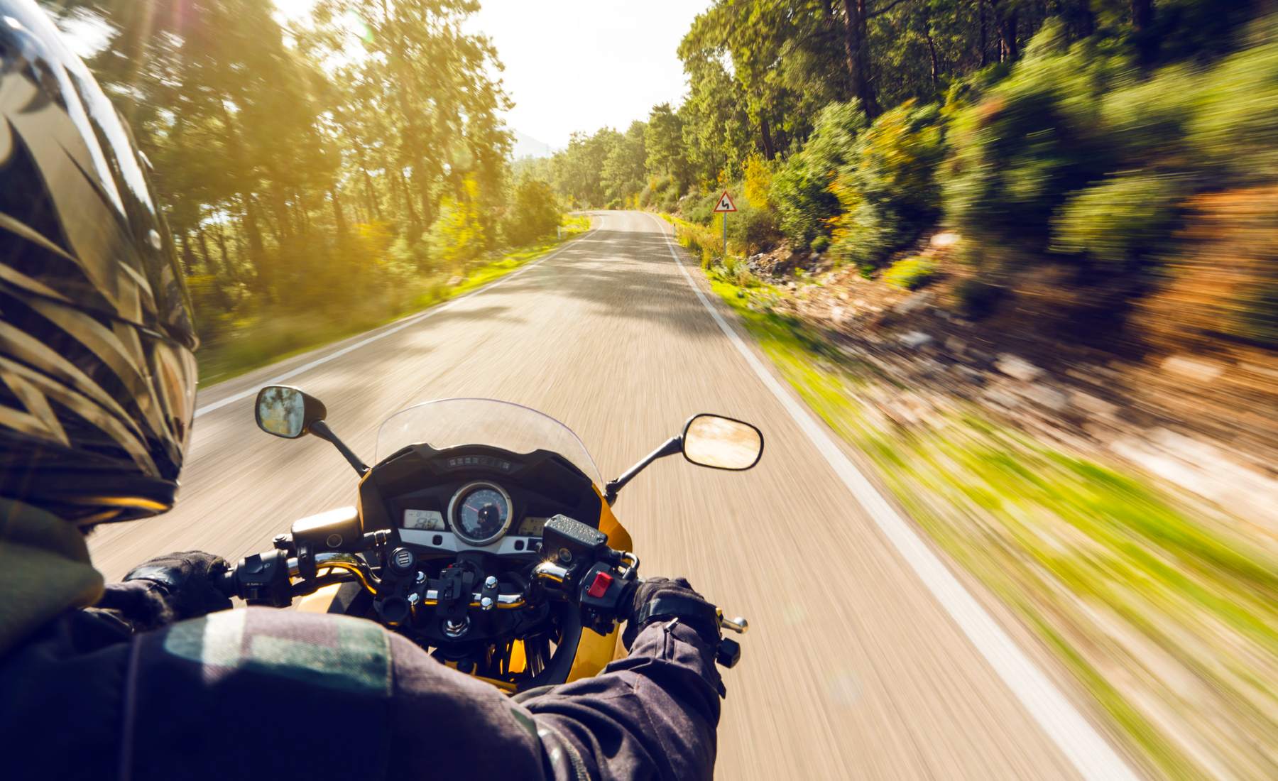 Motociclista conduciendo por la carretera