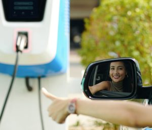 Mujer punto carga coche eléctrico