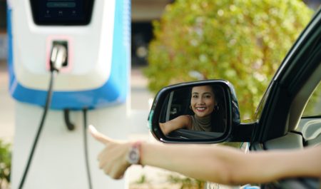 Mujer punto carga coche eléctrico