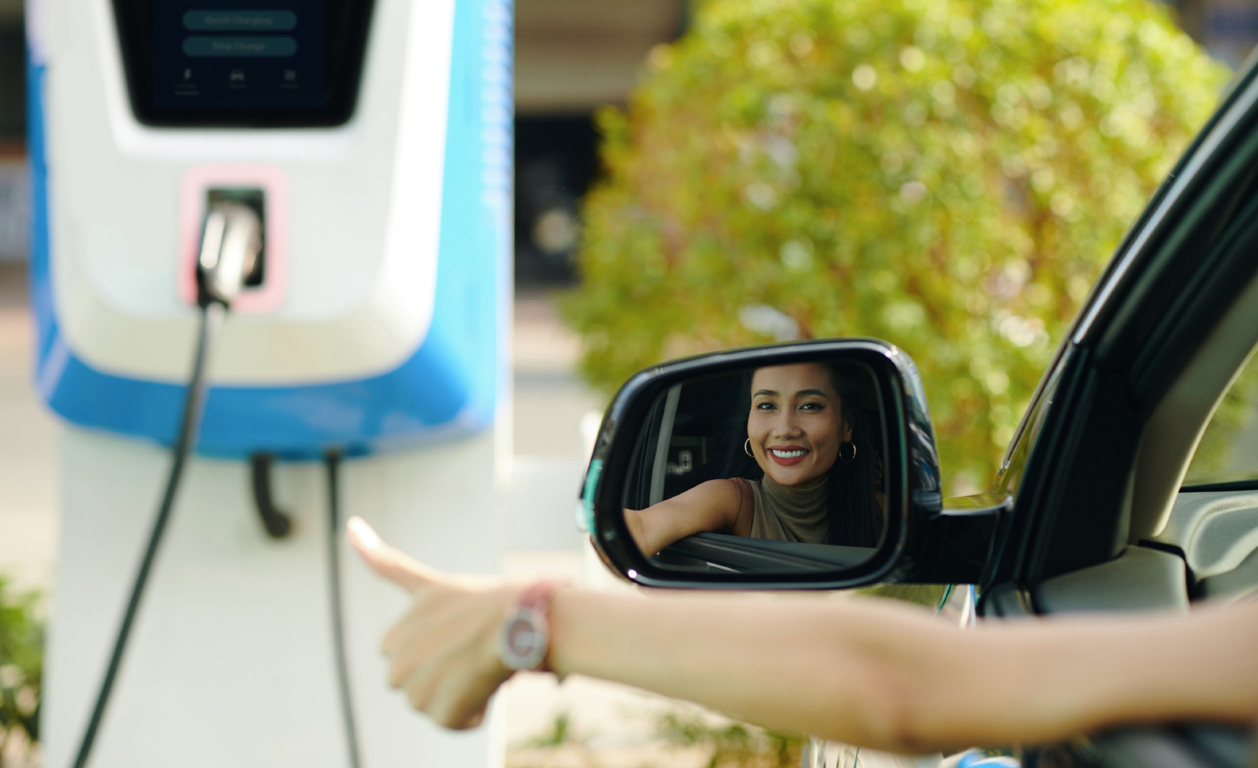 Mujer punto carga coche eléctrico
