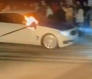 Uno de los vehículos derrapando con fuego a su lado.