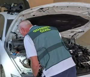 Un agente inspeccionando un vehículo.